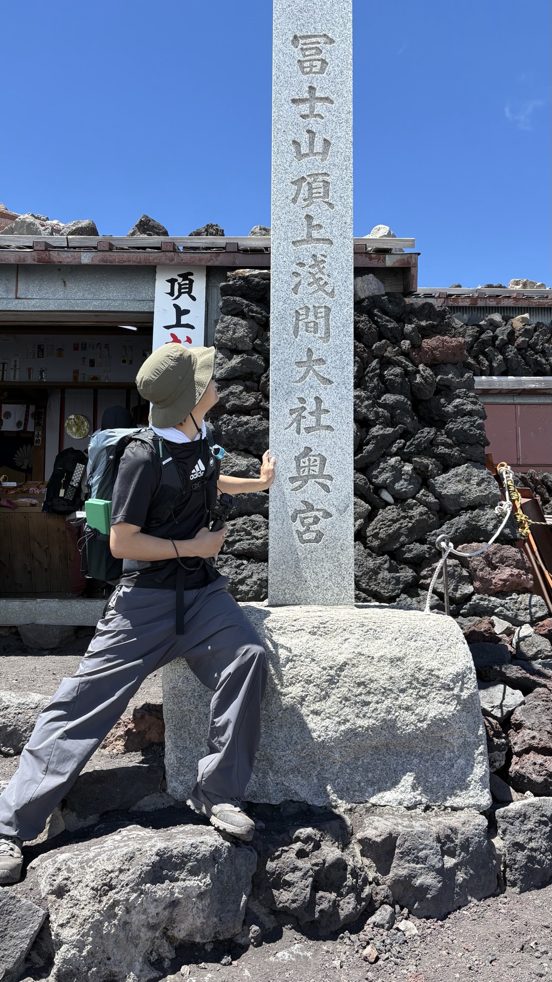 冨士山頂上浅間大社奥宮の石碑と登頂した登山者