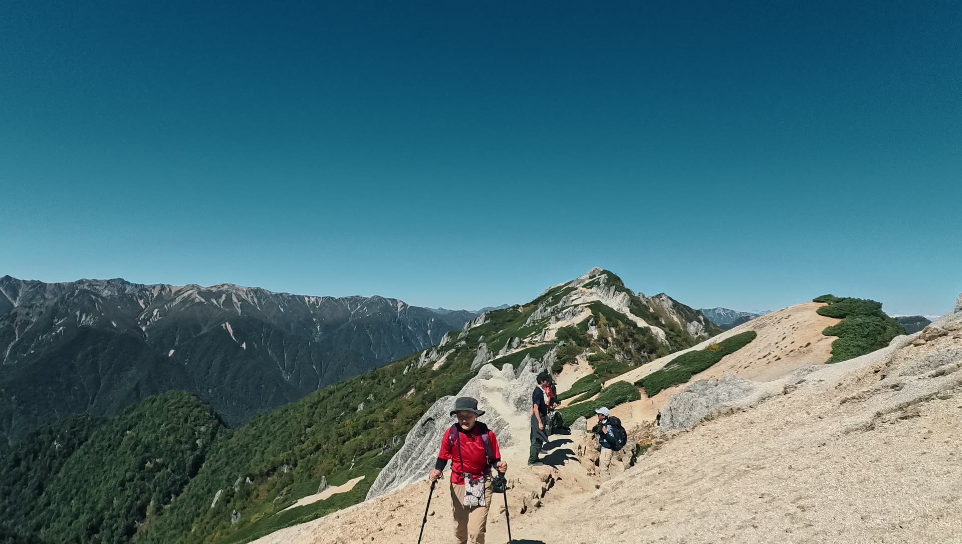 燕岳山頂へ続く白い砂の稜線を歩く登山者